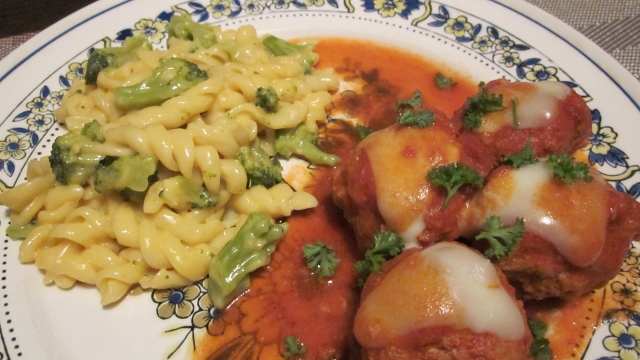Serving suggestion: Meatballs are topped with small cuts of mozzarella cheese and freshly cut parsley paired with a rotini and broccoli cheese blend.