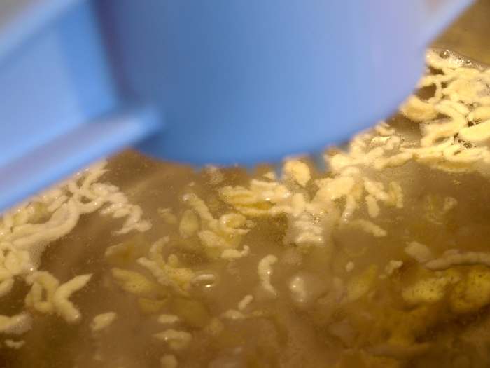 The batter drops from the bottom of the maker into the water, and the noodles start to float to the top quickly.