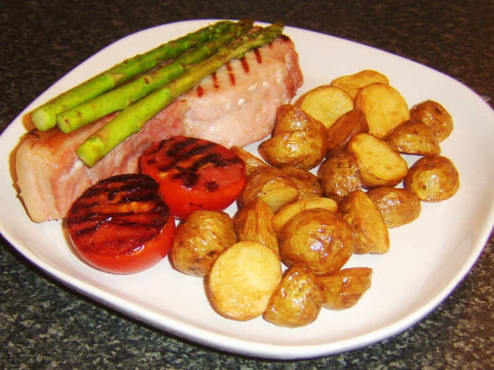 Griddled sweetcure bacon steak served with griddled asparagus and tomato with mini pan roasted potatoes