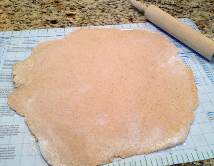 Roll out pizza dough on a floured surface to about a 14-inch circle. Carefully transfer dough to heated pizza stone (or other pizza pan).