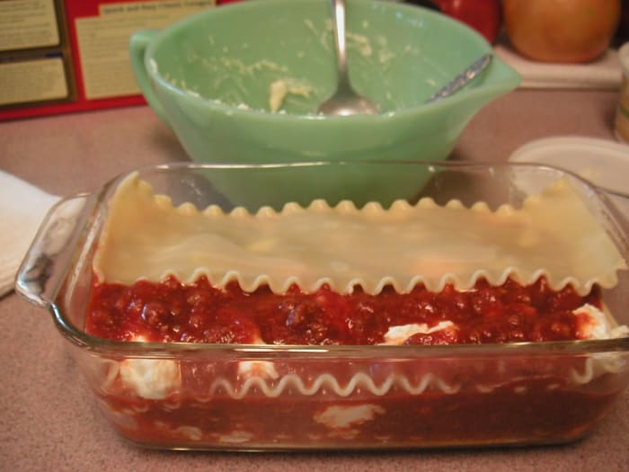 On top of the end layer of sauce, sprinkle a small amount of shredded Mozarella cheese and shredded Parmesan cheese if desired before baking.