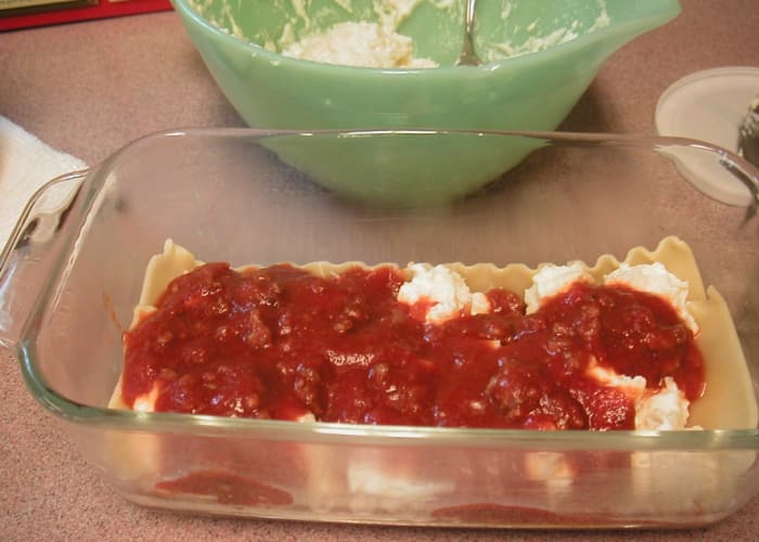 Spoon more sauce to cover the cheese mixture then continue layering the casserole ending with sauce on the top.