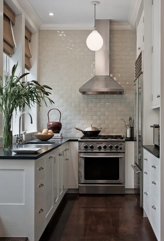 The light colored tile and cabinets contrast with the dark countertops and floor and help the U-shaped space feel more open.