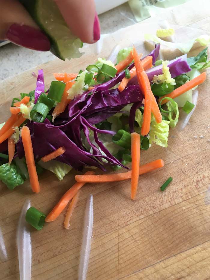 Once everything is chopped, mix it together, place the mixture on the tacky rice-paper roll, and spritz some lime juice on it.