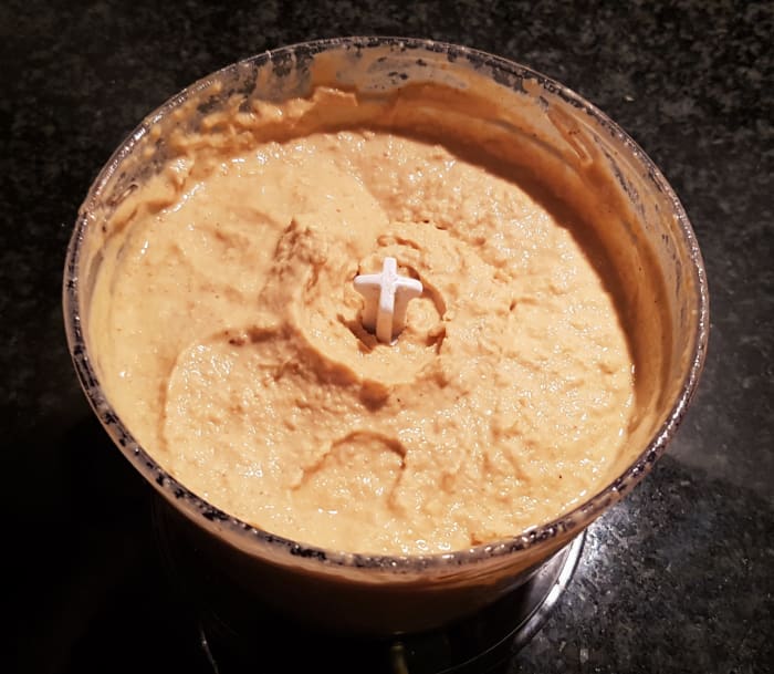 Steps 3 and 4: Add half of the can of chickpeas and process on the medium setting, scraping down the sides as you do. Then add the remainder of the chickpeas, scraping down the sides and adding water as necessary.