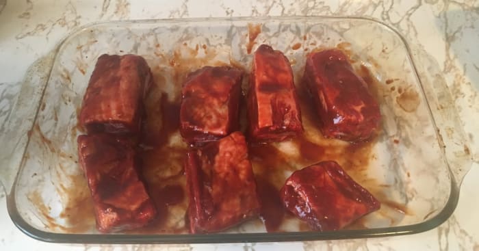 Each side of the ribs needs to be covered in Famous Dave's BBQ sauce. Once that is done, put the tinfoil on and place them in the oven.