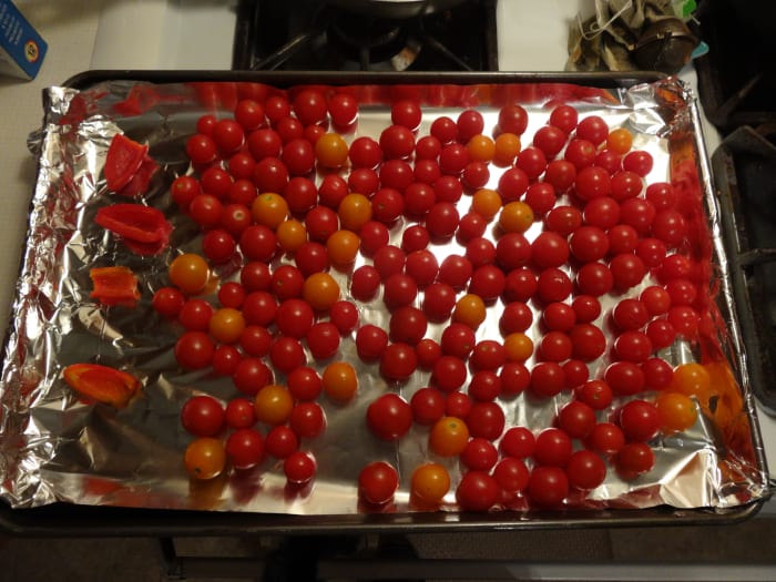 Place jalapeno pepper halves and cherry tomatoes in a single layer on an aluminum foil lined baking sheet.