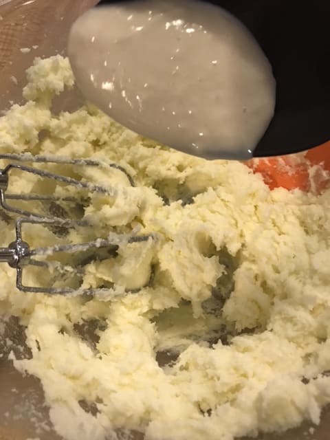 Once the butter and sugar are light and fluffy, begin slowly working in the milk/flour mixture. Work by dropping in large spoonfuls, and beat well between each addition.