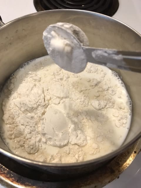 Whisk the flour into the milk while it's still cold, If the milk is warm or hot, the flour will lump and you'll never really get it smooth. Whisking well while the milk is still cold ensures a smooth final result.