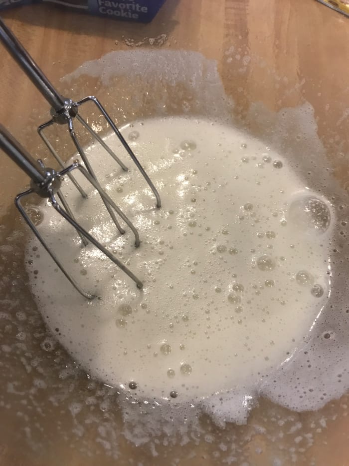 Remove the bowl from the heat once the sugar has dissolved and the egg whites are white and frothy. Beat with a mixer until stiff, glossy peaks form.