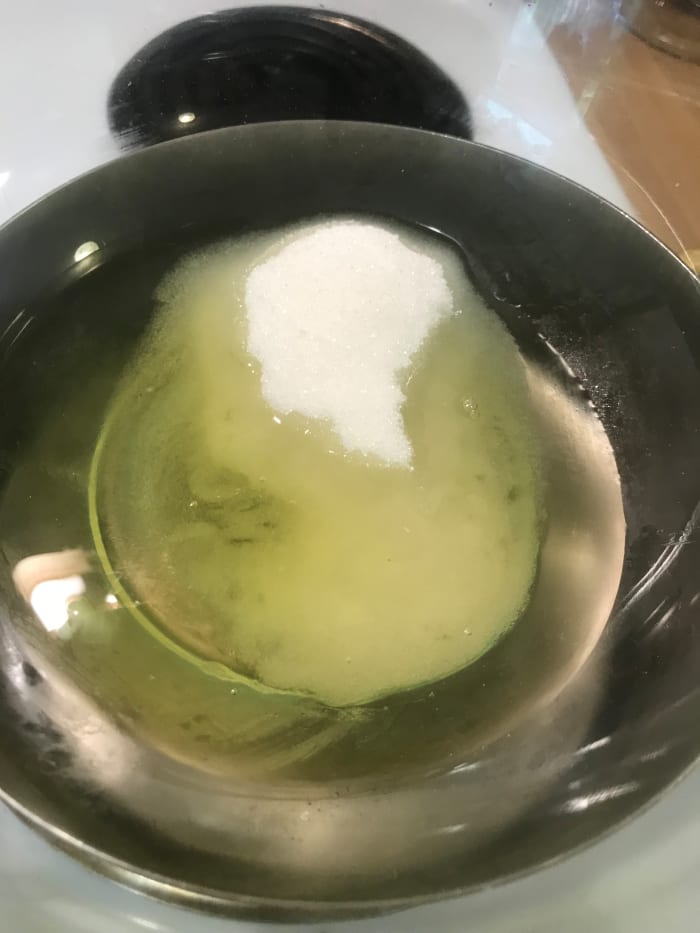 Whisk together sugar and egg whites over barely simmering water. Whisk until the sugar is fully dissolves and the egg whites turn white and frothy.
