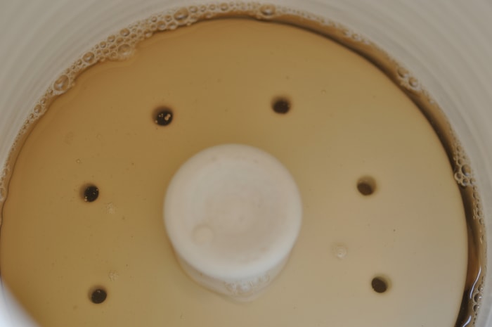 The weighting lid that comes with the olive brining jar keeps the radish batons submerged in the syrup.