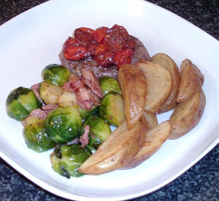 Wild boar and apple burger, topped with homemade tomato chutney, is served with Brussels sprouts and bacon and homemade wedges