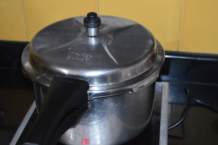 Step nine: Close the lid. Put cooker weight. Cook up to 2 whistles. Simmer for 4 minutes. Next, turn off the heat.