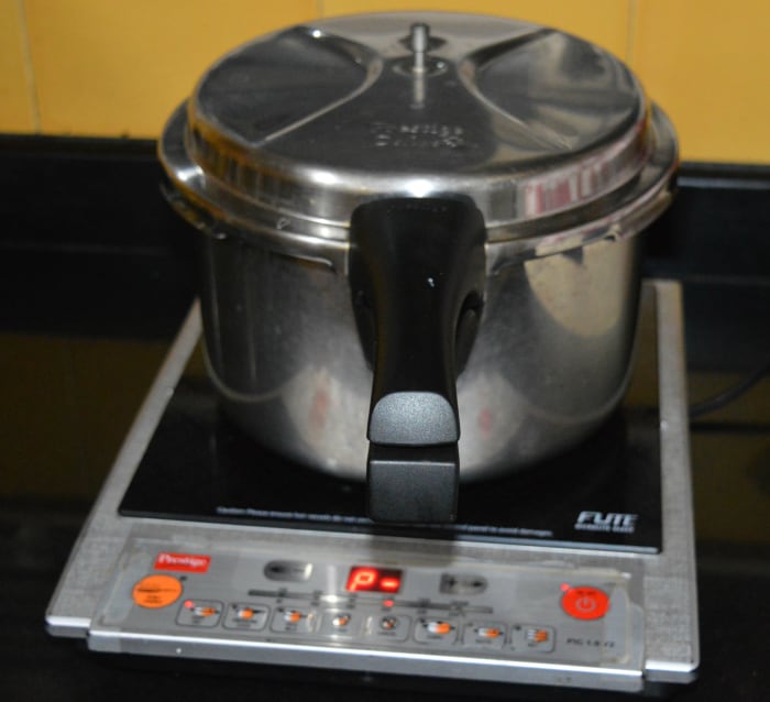 The cooker with the idli stand inside. Set the heat on medium-high. Steam-cook up to 10 or 11 minutes. Next, turn off the heat. Open the lid after 2 to 3 minutes.