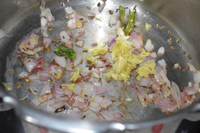 Step three: Add chopped onions. Stir-cook them until they are golden brown. Next, add crushed ginger and garlic. Saute for a few seconds.