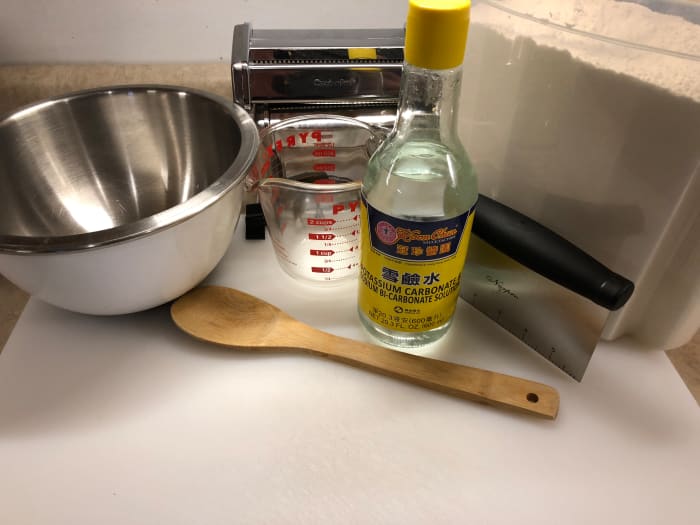 You will need a bread flour, sodium bicarbonate, warm water, a bowl, wooden spoon and a knife of some sort.