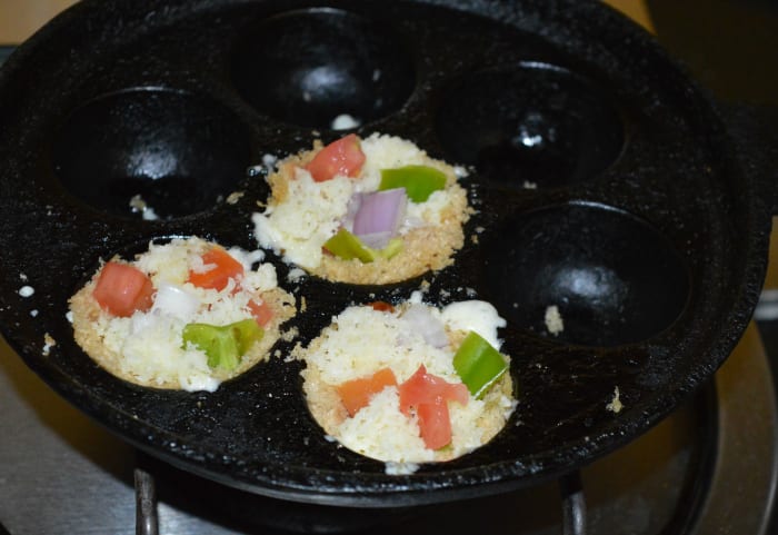 Step six: Add grated mozzarella cheese. Add Italian seasonings and salt-pepper powder on the top. Cover the pan. Keep the pan on medium heat.