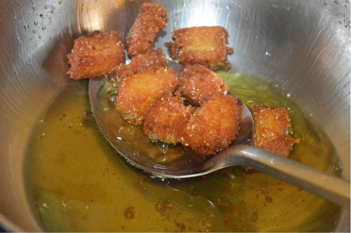 Remove them and drain the excess oil. Put them into the hot sugar syrup. Fry all the idli pieces and put them in the syrup. Turn them once, so that each chunk absorbs sugar syrup. Set it aside.