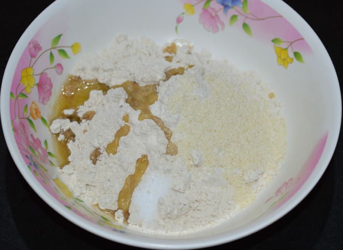 Step two: Take wheat flour, semolina, ghee, oil, and salt in another bowl. Knead, adding jaggery water little by little to get a firm and pliable dough.