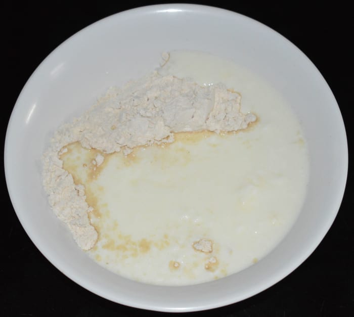 Step two: Mix wheat flour and yogurt or curds in a large mixing bowl. Add water to adjust the consistency.