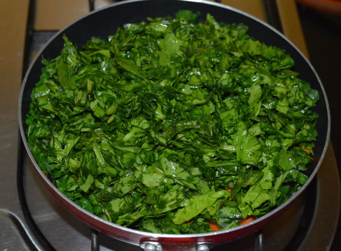 Step four: Add chopped spinach. Cover the pan. Cook over medium heat for five minutes. No need to add water. Spinach will release its water.
