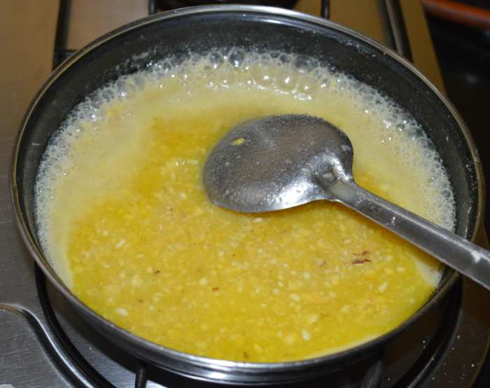 Stir-cook continuously over low heat while scraping the sides until the mixture becomes hard and leaves the bottom, forming a single lump.