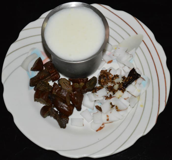Step two: Add chopped pickled mangoes, grated coconut, roasted cumin, and broken dry red chili in a mixer or blender.