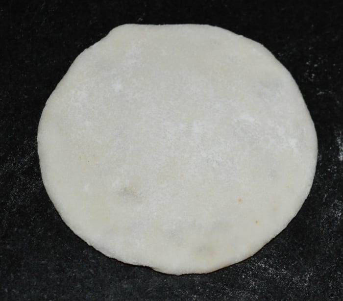 Step four: Roll it in such a way that the stuffing will not come out. You can use all-purpose flour for the dusting. Make the discs of about 3 1/2 inches diameter. Make all of the discs and keep them ready.