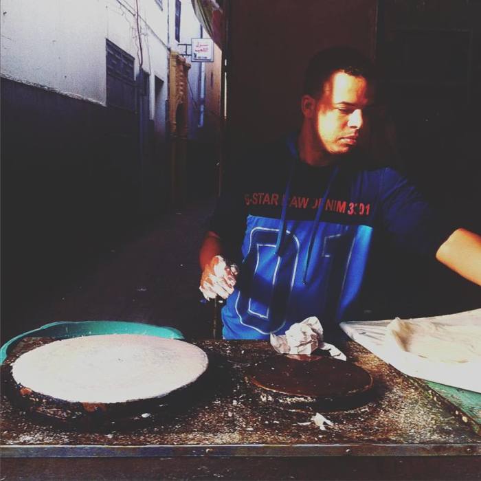 Preparing the waraq (papers). A man in the Rabat medina deftly transfers the raw filo dough to a hot circular griddle. These layers will be used to make flaky pastilla.