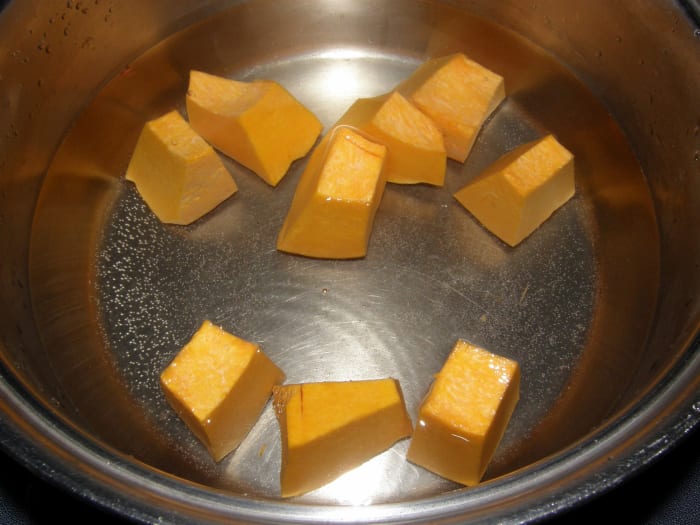 When the water has reached the boil, add the pumpkin cubes. The pumpkin will help to give the soup some color.