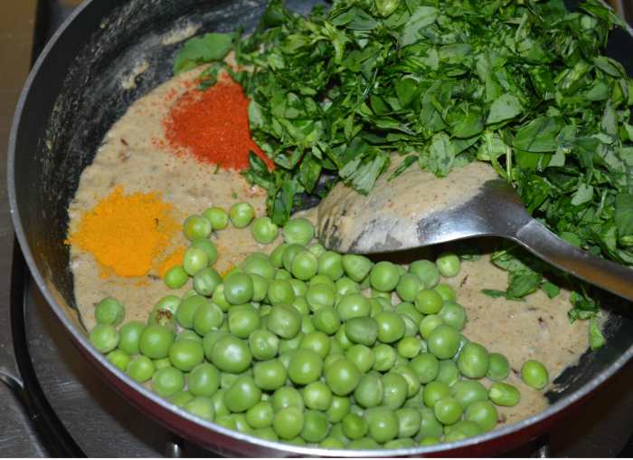 Step five: Add the green peas, chopped fenugreek leaves, turmeric powder, red chili powder, salt, and sugar. Mix thoroughly.