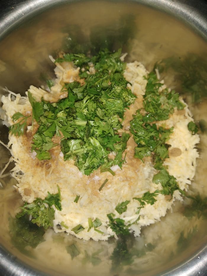 In a bowl, add mashed potato, grated paneer, cumin powder, coriander powder, salt, red chili powder, and coriander leaves.
