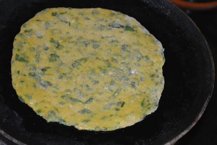 Step three: Heat a flat pan or griddle. Add a few drops of oil or ghee. Place a disc in the center. Roast both sides of the disc, adding a bit of oil or ghee.