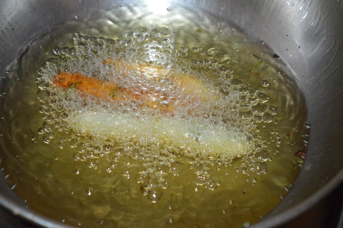 Step four: Make your fingers oily. Take a small portion of the dough in your fingers. Press it and make a round shape. Elongate to make a cylinder shape. Slide it in hot oil. Dep-fry it.