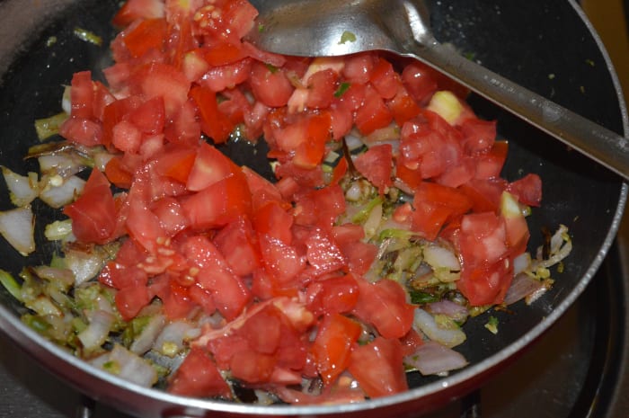 Step two: Add chopped tomatoes. Increase the flame. Add some salt. Cook while stirring occasionally until tomatoes become a bit mushy.