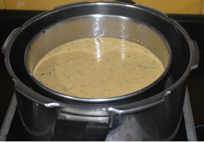 Step three: Check the consistency of the batter. If it is thick, add some water and mix well to bring it to the idli batter consistency. Add lemon juice and fruit salt or baking soda. Gently mix the batter once. Quickly pour it into the greased tin.