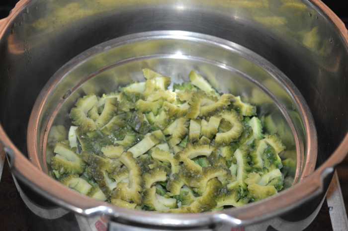 Cook the bitter gourd in a pressure cooker up to 2 whistles and simmer for 2 to 3 minutes. There's no need to add water to the bitter gourd.