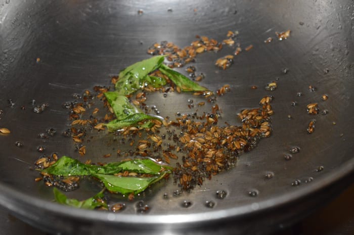 Step 1: Heat oil in a deep-bottomed pan. Add mustard seeds. Allow them to crackle. Throw in cumin seeds and curry leaves. Saute for 10 seconds. Reduce heat to minimum.