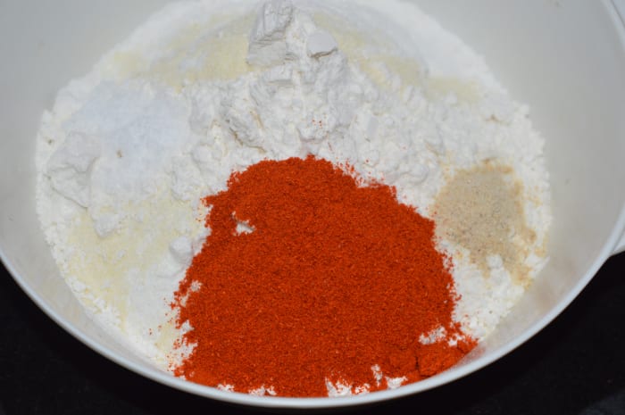 Step 1: In a large mixing bowl, add rice flour, all-purpose flour, semolina, red chili powder, sesame seeds, asafoetida powder, and salt.