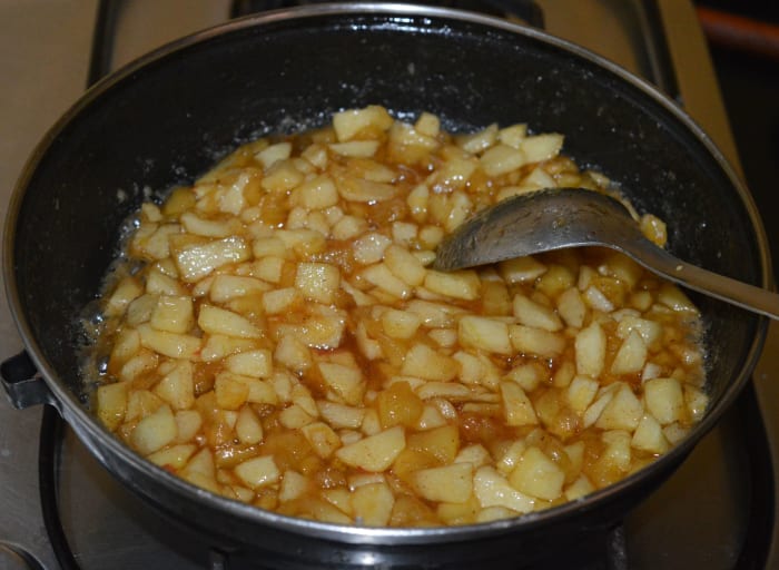 Step two: Add apple cubes. Cook the mixture until the apples shrink and the mixture becomes semi-solid. Turn off heat. Set aside to cool. This is the stuffing for the pies.