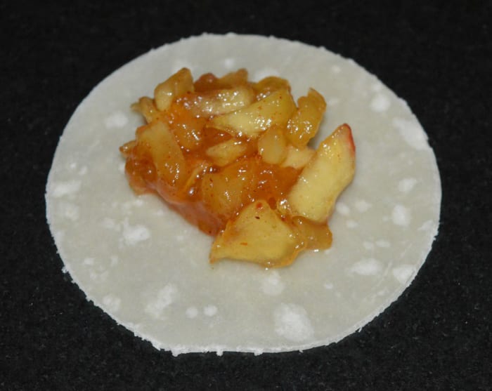 Step five: Take one small tortilla disc. Place a teaspoon of the stuffing in the center. Place another disk on top of it. Seal the edges with the all-purpose flour batter.
