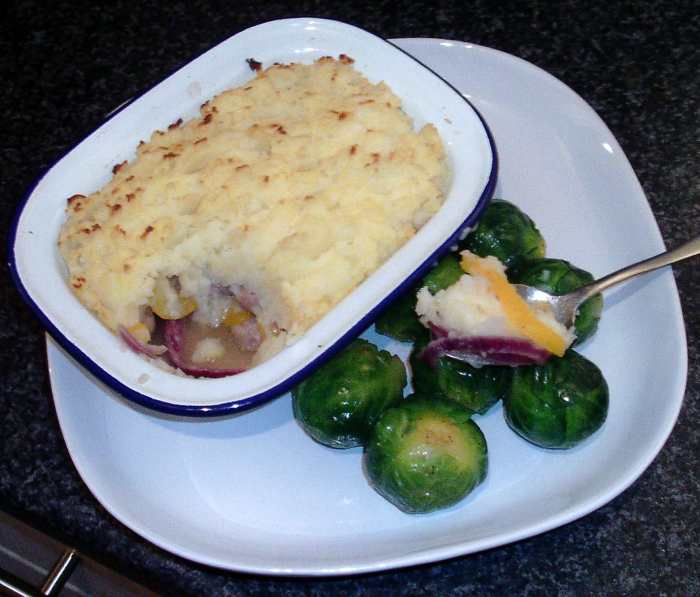 Sausages, peppers and onion topped with mashed potato pie, served with nutmeg spiced Brussels sprouts