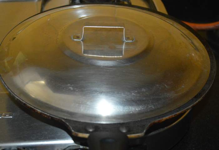 Spread it on all sides equally while wetting your fingers with water to make a moderately thick disc. Cover the pan and cook for 2-3 minutes over medium heat. You can observe that the top side of the pancake appears dry.