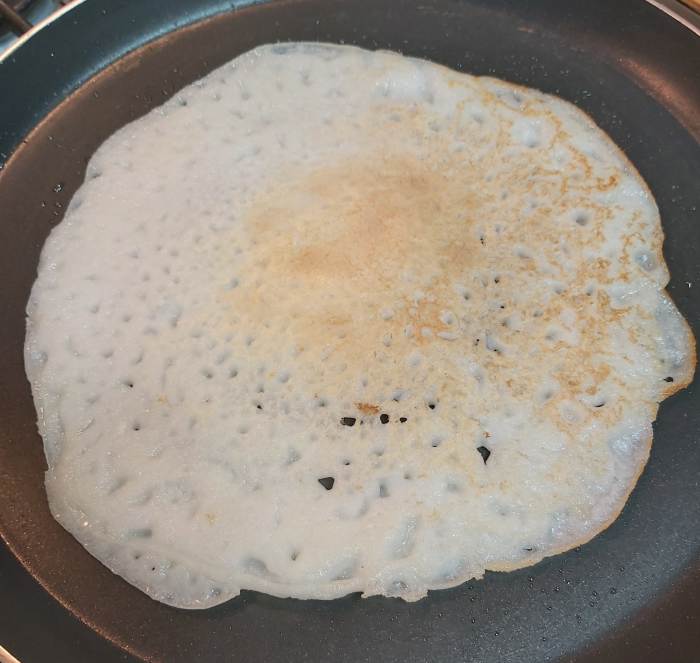 Cover and cook on medium flame. Once cooked completely, flip the dosa to cook the side. (You can see how it is a light golden brown). Repeat the process with the remaining batter.