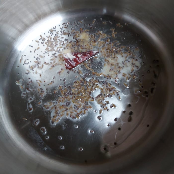In a pan or vessel, heat the oil and splutter 1/2 teaspoon of mustard seeds and 1/2 tablespoon cumin seeds. Add 1-2 broken red chili and asafoetida. Fry.