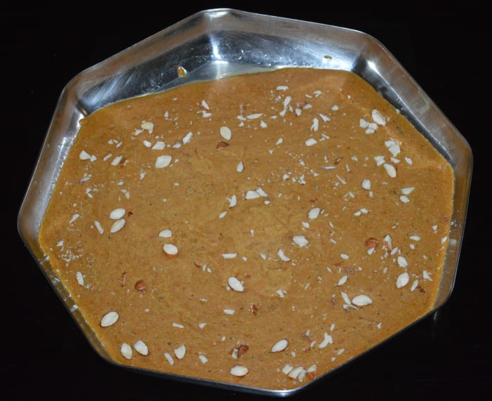 Spread the almond slices evenly on top. Press it down gently to ensure that the almonds are firmly sitting on the burfi.