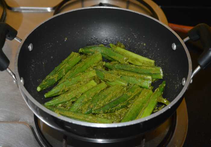Step six: Place the stuffed okra on it one near the other. Cook it on medium heat for 2-3 minutes. Sprinkle a few drops of water if needed. Turn the okra.