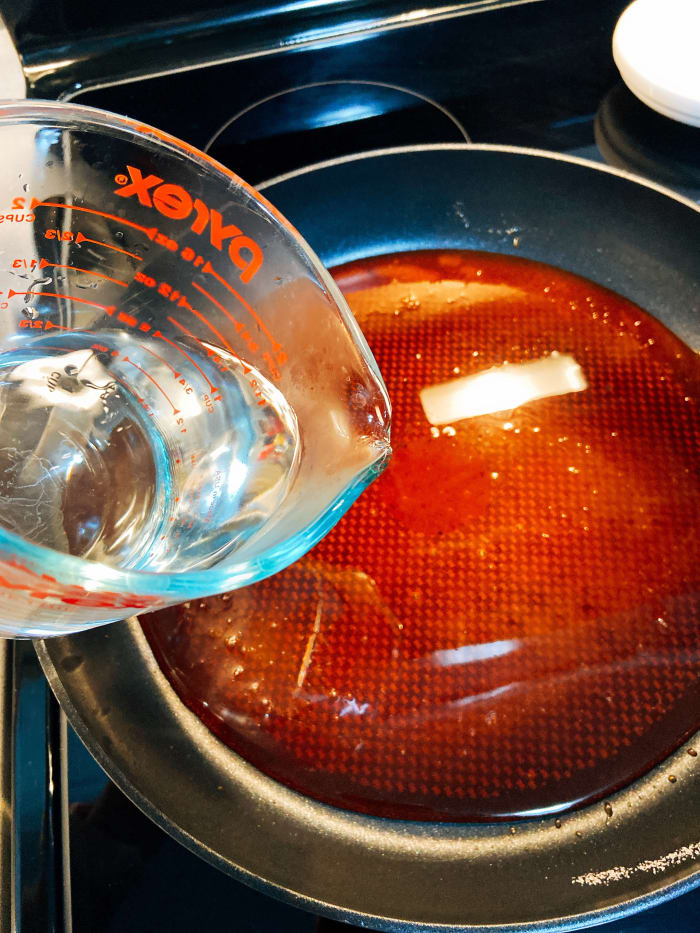 After the sugar has turned to the caramel, turn off the heat and gently pour in 1 cup of hot water. Use a spatula to combine. Set aside to cool.