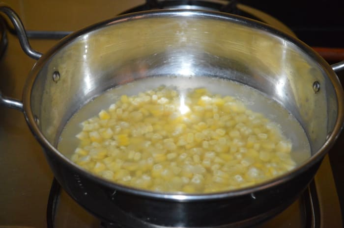 Step two: Add the remaining sweet corn kernels to a deep-bottomed pan. Add 4 cups of water. Bring this mixture to a boil.